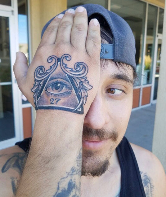 Realistic eye tattoo on mans hand